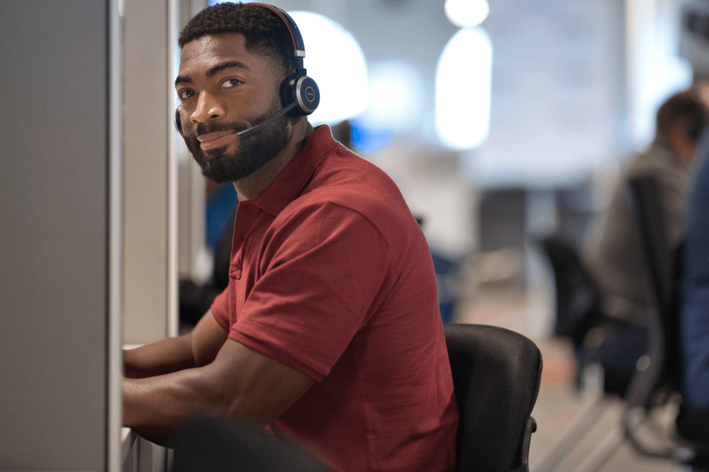 person sitting at desk with phone headset