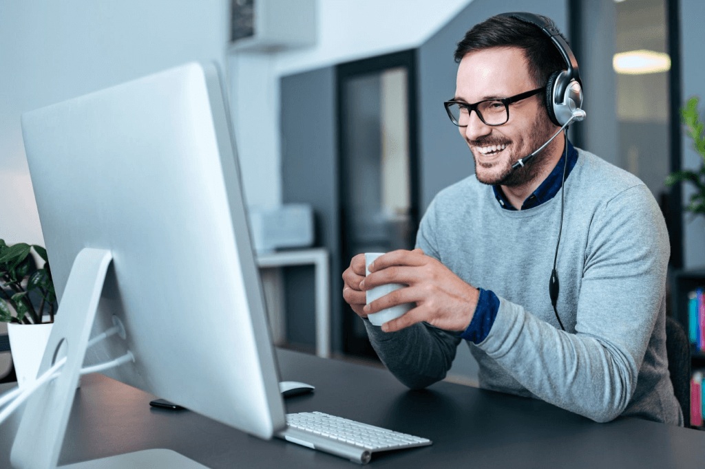 person with headset looking at computer screen